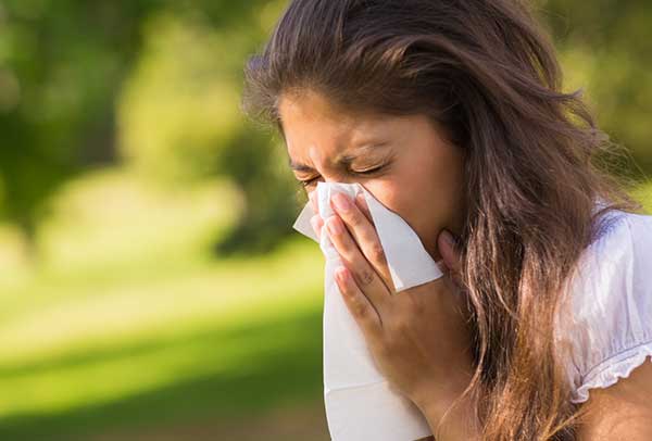 lady sneezing in park